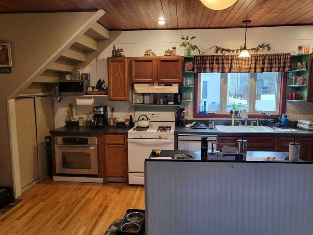 Photo of a kitchen with wood cabinets and black countertops.